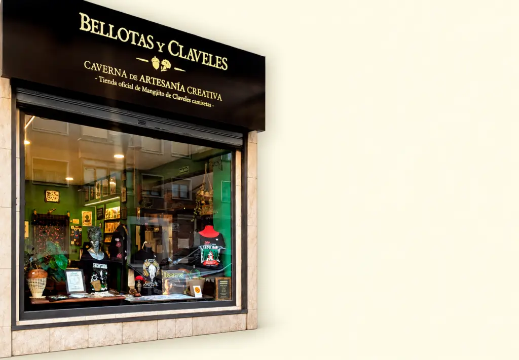 Escaparate de Bellotas y Claveles con el rótulo de la tienda, camisetas y objetos ilustrados